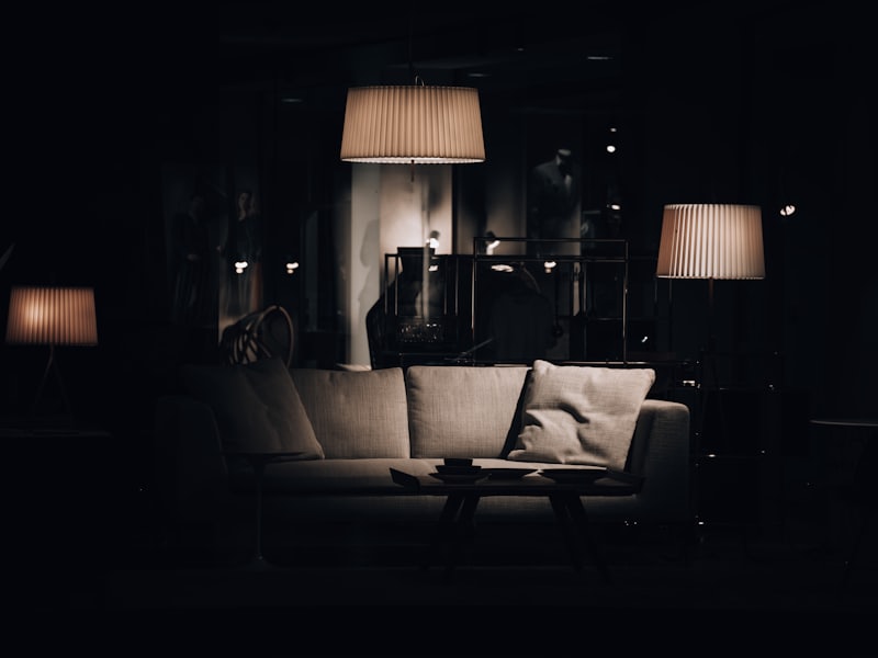 A living room lit only by table lamps late at night, the couch empty.