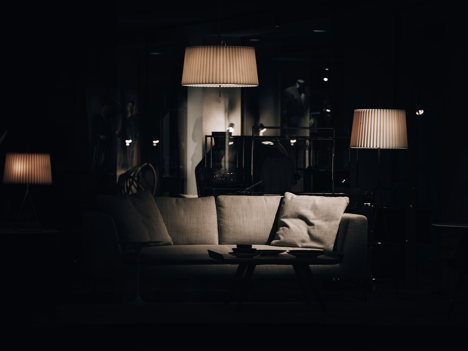 A living room lit only by table lamps late at night, the couch empty.